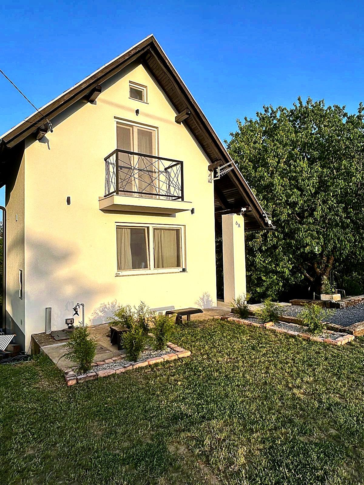 Facade of the Tri Trešnje house with a lush lawn