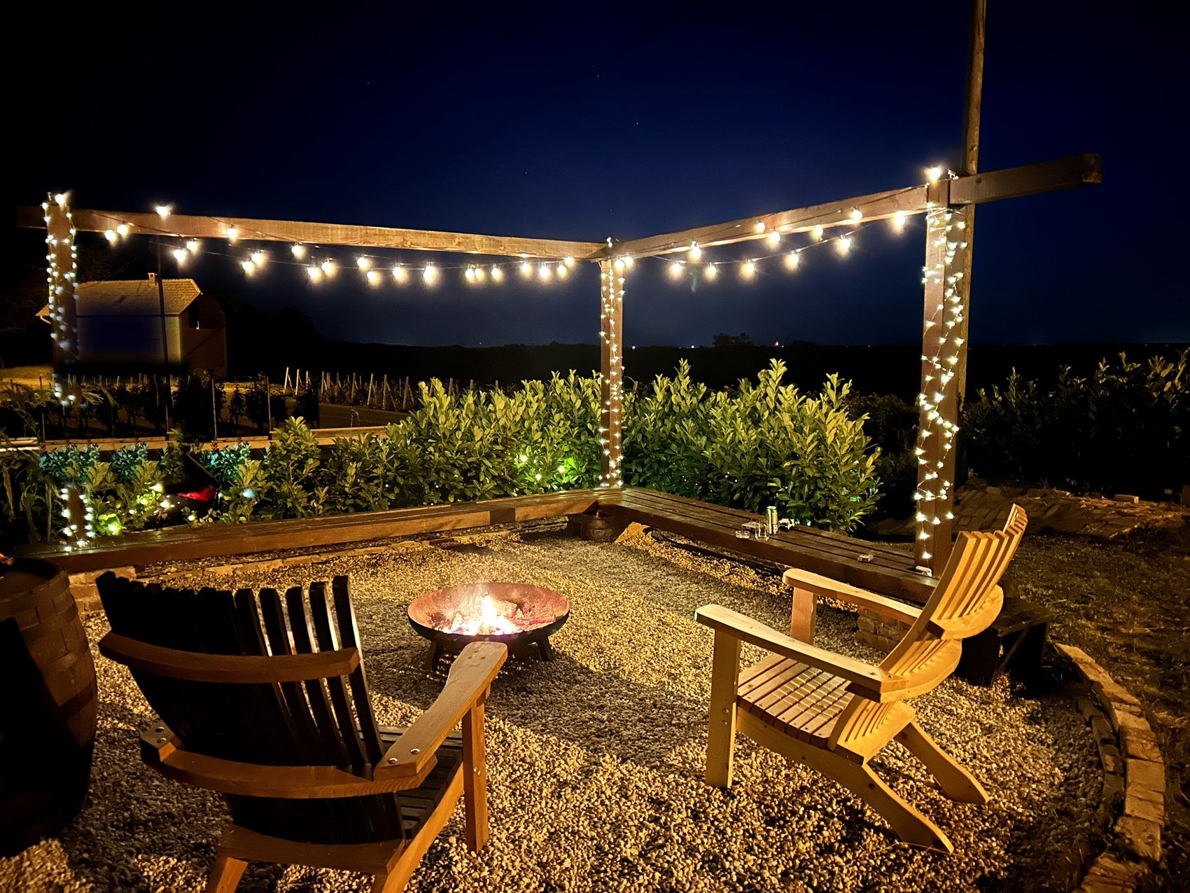The fire-pit lounge lit by fairy lights in the evening